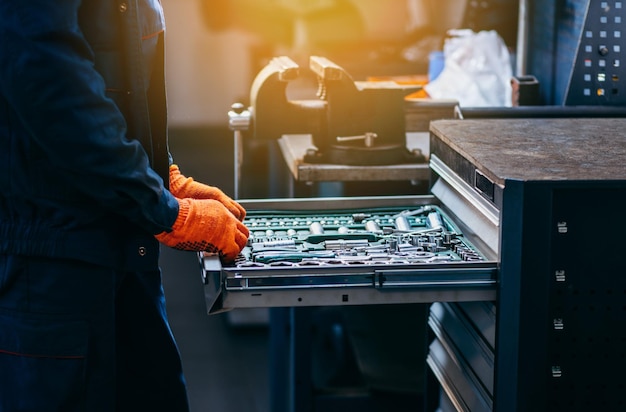 Close up of hands of auto mechanic selecting tools in car repair shopClose up of hands of auto mecha