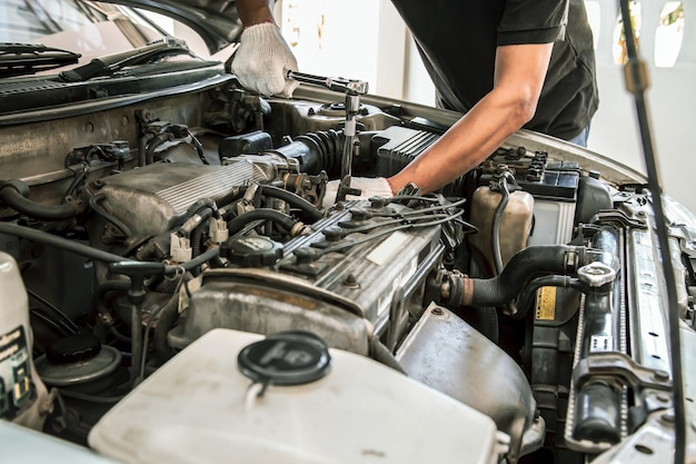 Close-up hands of auto mechanic using the wrench to maintenance car engine.