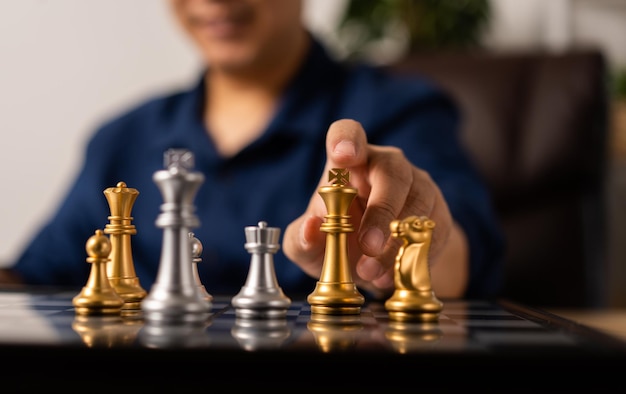 Close up of hands of a business man moving king golden chess to defeat opponent the chess game