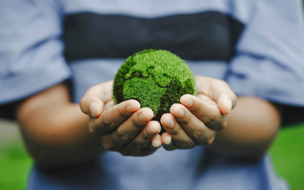 Photo close up of hands holding the earth on a green background protect nature save earth concept of the environment world earth day