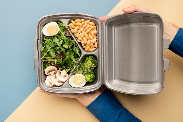 Close up hands holding food container