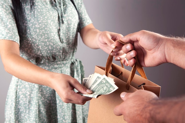 close up of a hands holding shopping bags and paying cash money dollars