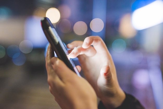 close up of hands holding smartphone