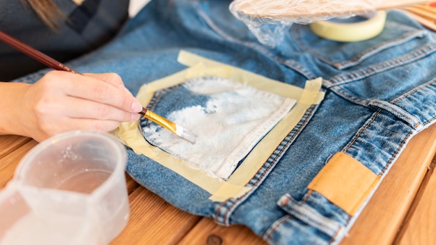 Close-up hands painting jeans