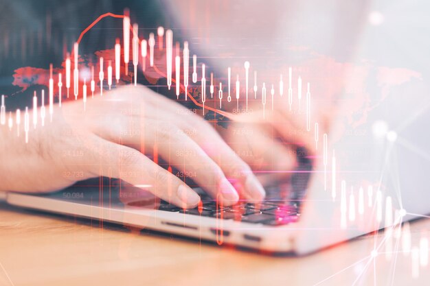 Close up of hands using laptop computer with glowing falling red forex chart on blurry background Stock exchange and crisis concept Double exposure