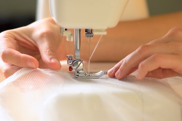 Close up hands using a sewing machine