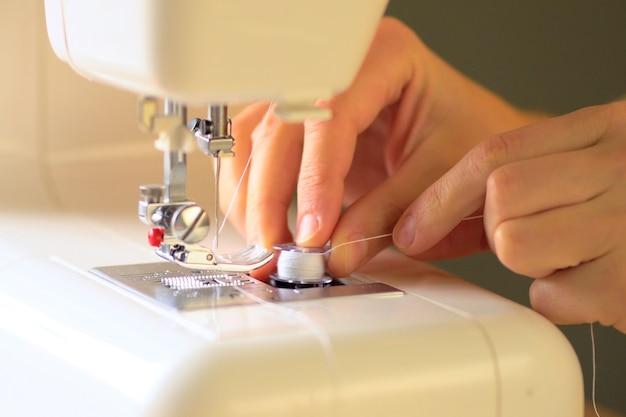 Close up hands using a sewing machine