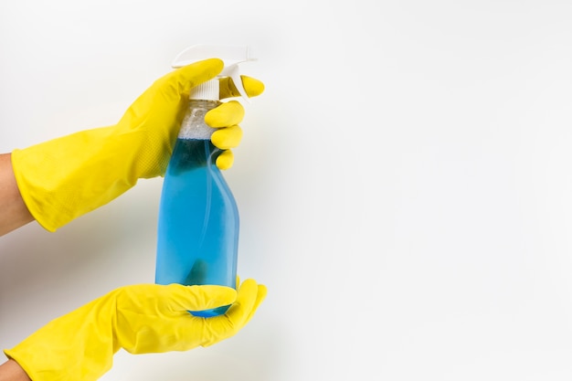 Close-up hands with gloves and spray bottle