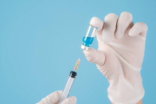 close up hands with sterile gloves and syringe