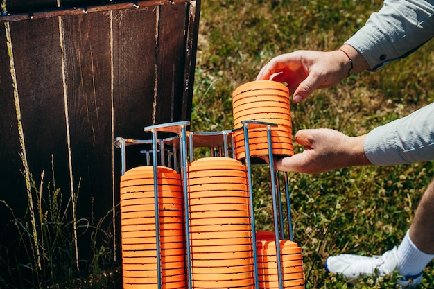 Close up hands of worker loading plat machine with orange shooting plate