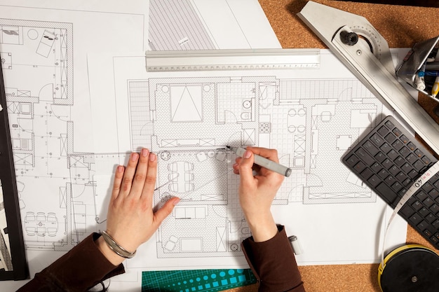 Close up of hands working on blueprints on table. Construction and architecture. Project and design