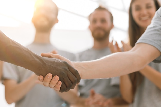 Close up handshake of two students on the background of the st