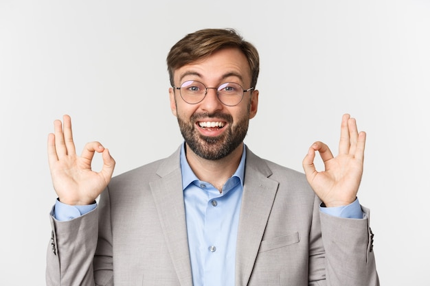 Close up of handsome confident businessman, wearing glasses and gray shirt