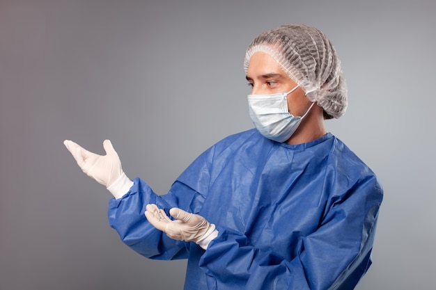 Close up on handsome male surgeon dressed in protective suit