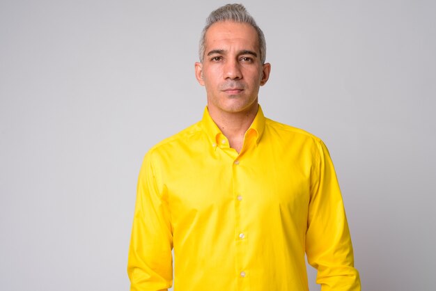 Close up of handsome Persian businessman wearing yellow shirt isolated