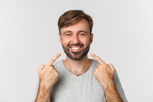 Close-up of handsome smiling man recommending dental clinic