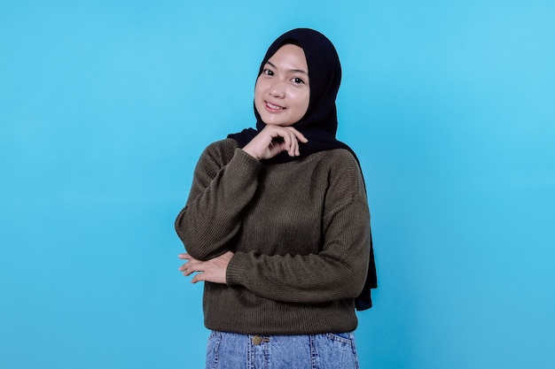 Close-up of happy girl wearing hijab in casual cloth and smiling on blue wall