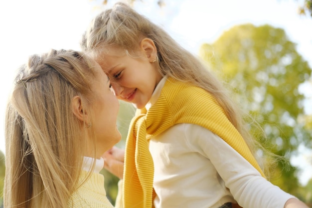 Close up of happy mother and daughter smiling touching with foreheads Horizontal photo