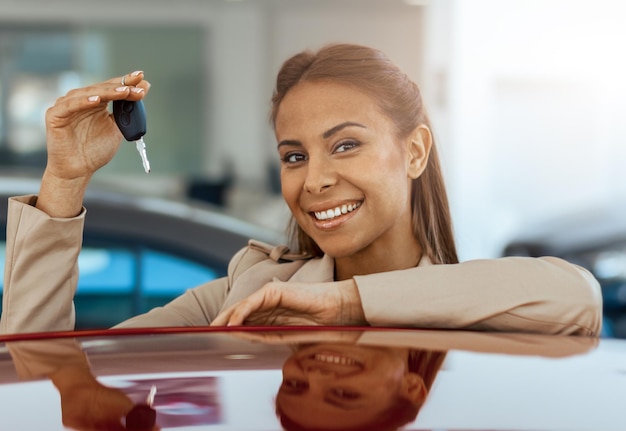 Close up of happy young woman holding key to her new car Concept for car rental