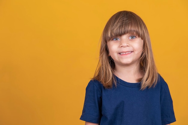 Close up headshot portrait image with brown haired smiling girl Happy cute kid concept with good healthy teeth for dentist on yellow background four years old kid looking at camera and posing