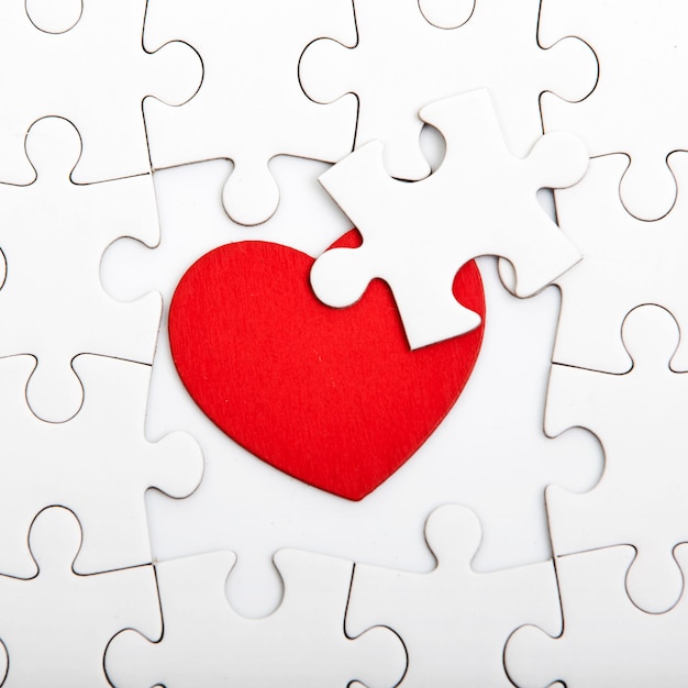 Photo close-up of heart shape amidst white puzzle on table