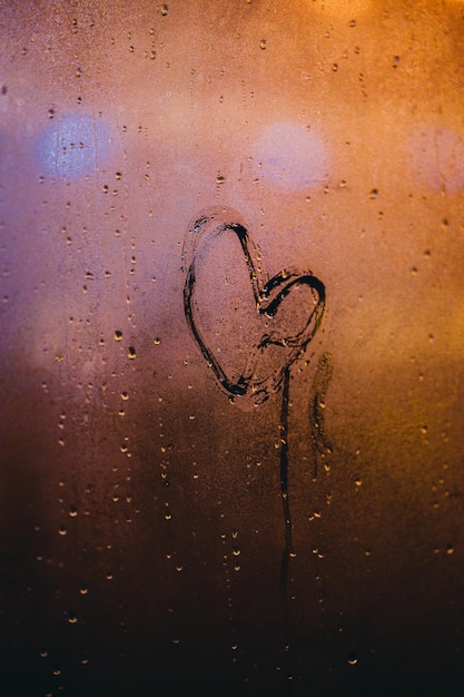 Photo close-up of heart shape on condensed glass