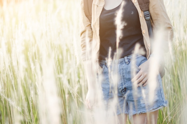 Close up hipster young girl with backpack hiking in forest