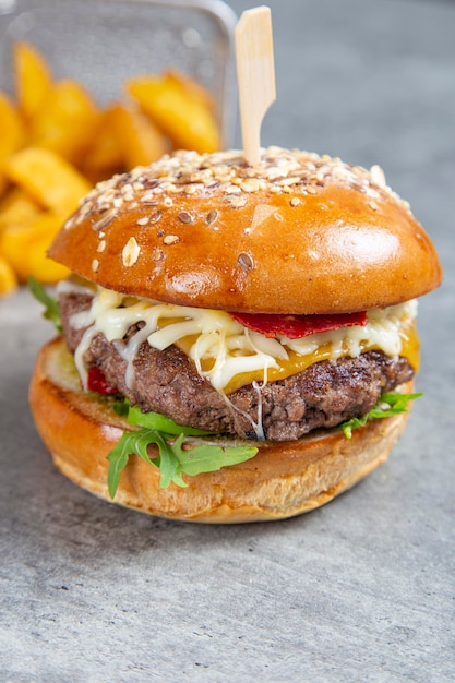 Close up homemade burger of beef cheese and vegetables on an old grunge table