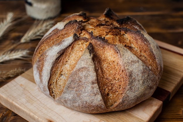 Close up of homemade whole grain sourdough bread on wooden board