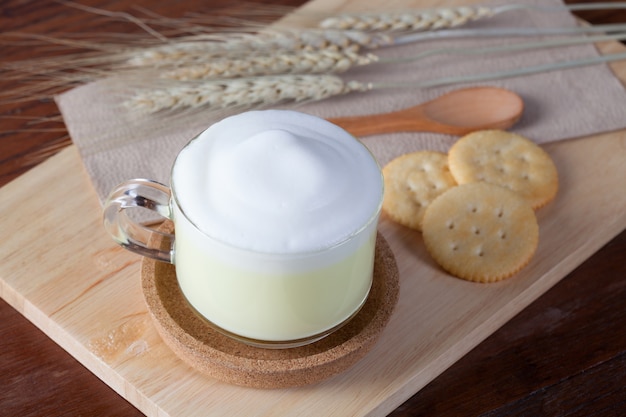 close up hot green milk with biscuits on wooden plate on wooden table for breakfast.