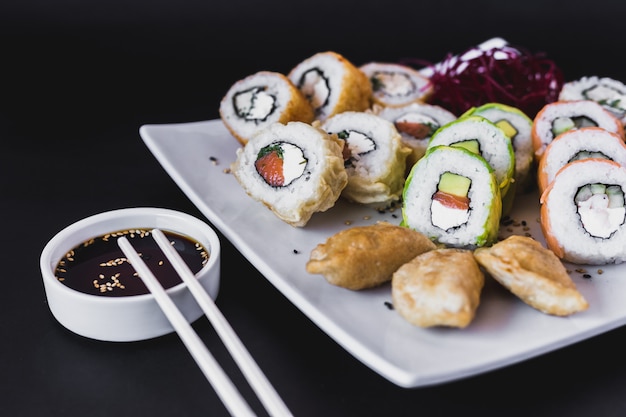 Close up Hot sushi rolls table with gyoza