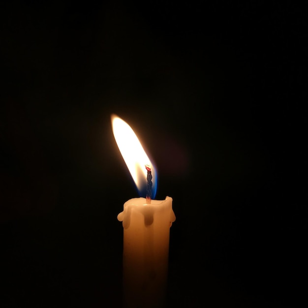 Close-up of illuminated candle against black background