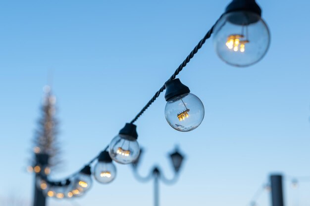 Photo close-up of illuminated light bulb against sky