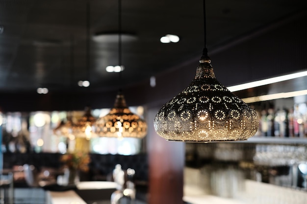 Photo close-up of illuminated pendant light hanging in restaurant