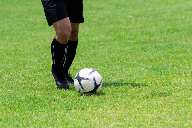 Photo close-up image, footballers are dribbling on the grass.