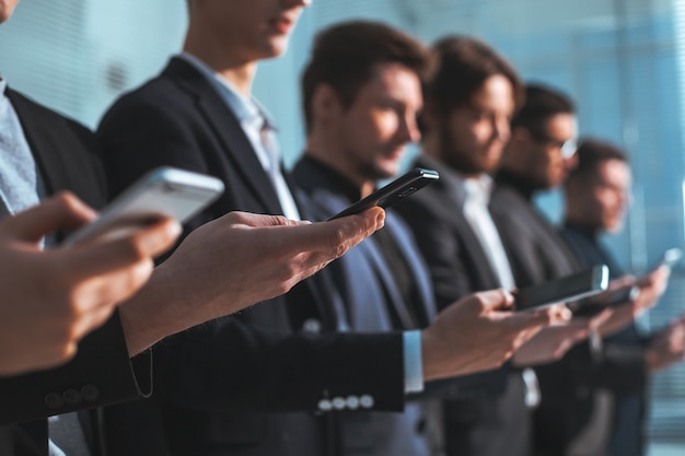 Close up . image of a group of young business people with smartphones . people and technology