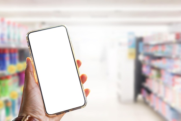 Close up image of hand holding smartphone with blank screen for shopping in supermarket