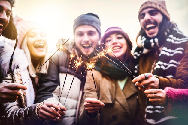 Close up image of happy friends enjoying out with sparklers