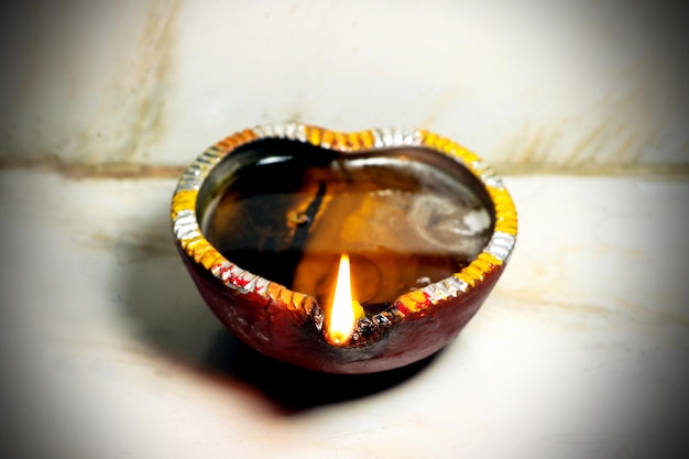 Close up image of a lit clay diya or lamp on floor on Diwali an Indian hindu festival of lights