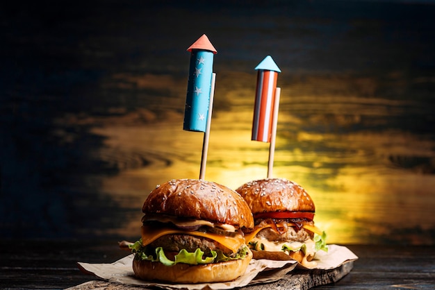 Close up Image of two beef burgers with fireworks rockets. picnic festive snack on the fourth of july independence day