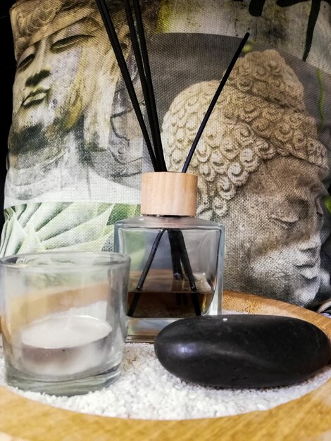 Close up of incense scented candles and Buddha showing concept of tranquility, relaxation, well-being and personal care