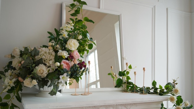 Close up of interior of one of corners of room Large mirror with decorative flowers and candles on white table