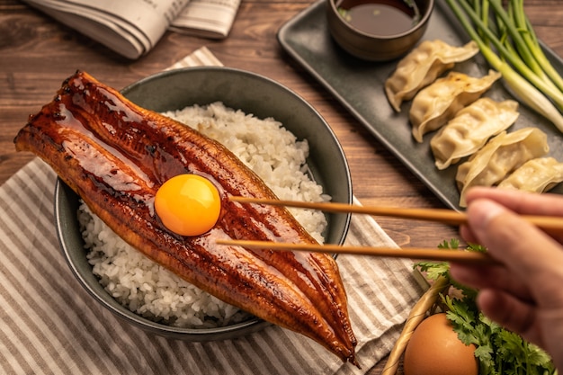 Close-up Japanese grilled eel served over rice or Unagi don set on plate. Japanese food on restaurant table