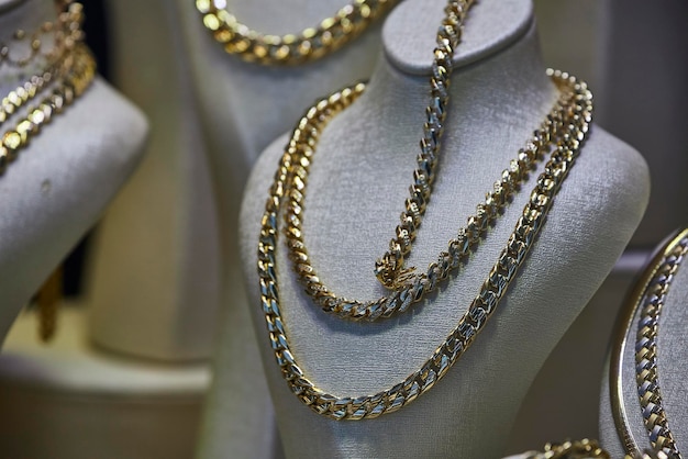 Close up of the jewelry gold necklaces ring chains show in beauty retail store window display showcase background