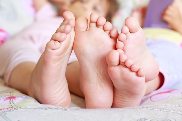 close up of kids feet sitting in bed