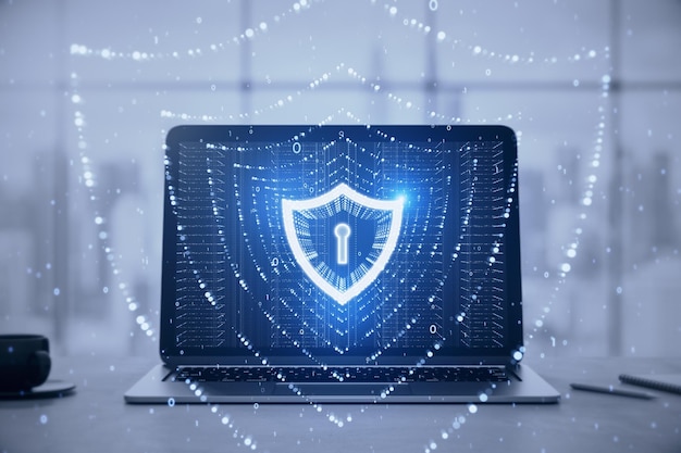 Close up of laptop on desk with coffee cup and glowing polygonal web security shield hologram on blurry office background Digital interface and protection concept Double exposure