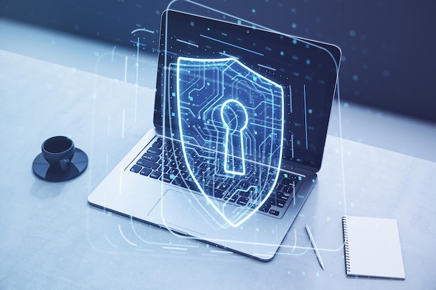 Close up of laptop on desktop with coffee cup notepad and glowing padlock hologram on blurry background Secure safety and web protect concept Double exposure