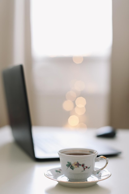 Close up of laptop keyboard with blank screen on a table by blurry bokeh lights background in the house or office modern sunlight in morning