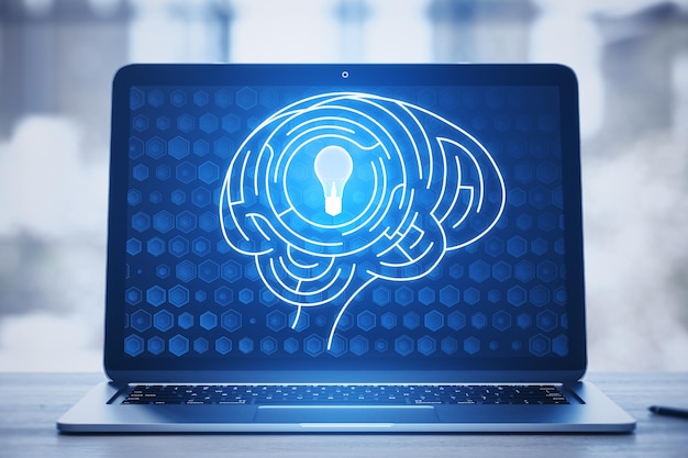 Close up of laptop keyboard with digital light bulb with human brain inside glowing on blurry blue background Creative innovation and inspiration Business and Technology idea concept