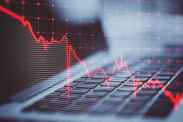 Close up of laptop keyboard with falling red business graph grid on blurry background Crisis recession and stock market concept Double exposure